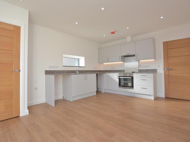 The first room to inspect on our tour is this modern and spacious kitchen/diner. It includes wall cupboards with under-lighting, base units and drawers with brushed metal handles, and work surfaces.