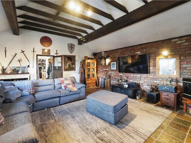 The extended lounge offers an ornate fireplace decorated with gold leaf, with an open fire for logs and coals, panelled walls, solid wood flooring, and a double-glazed bay window to the front elevation.