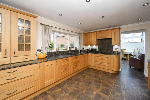 The kitchen is fitted with a range of matching wall and base units, as well as complementary, granite work surfaces and an inset sink and drainer unit. There are also ceiling spotlights, double-glazed windows to the side and rear of the house and an opening through to the conservatory.