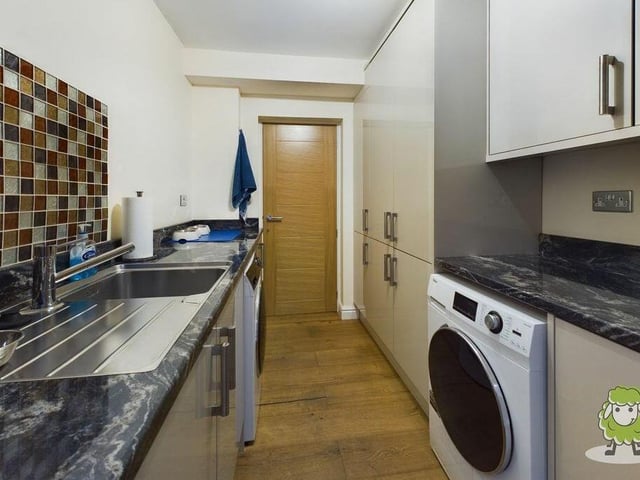 Just off the kitchen is this very useful utility room, with storage, sink and space for a washing machine. It also has access to the property's tandem garage.
