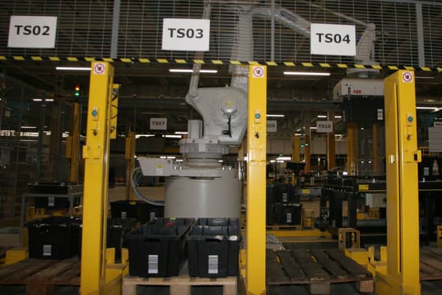 A robotic arm moving totes of Amazon products.