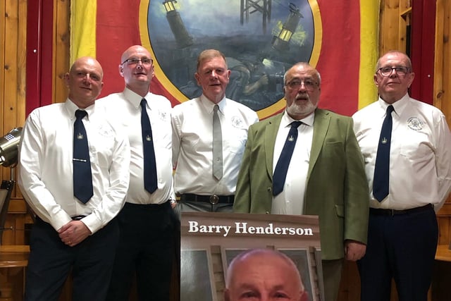 A committee of ex-miners formed for the planning of the statue. Here members pose for a photo with the restored Derbyshire Area NUM banner, alongside a photo of the late Barry Henderson, who brought forth the idea of a commemorative statue to honour the area's fallen miners.