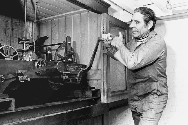 George Bird winds the clock above the Metal Box Factory in Mansfield in 1977.
