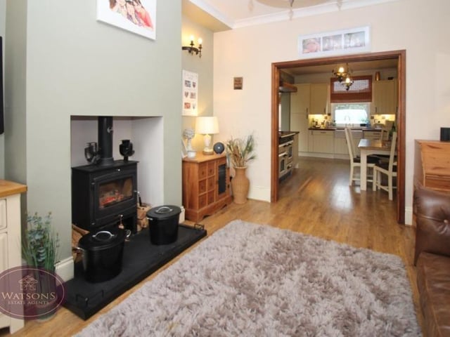 The lounge features an attractive inset fireplace space for a woodburner. Engineered wooden flooring adds to the character of the room.