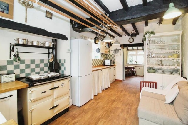 The busy and well-appointed retro kitchen and dining area combines functionality and style. The ceiling beams take the eye but the gas-fired Rayburn Aga cooker is a central focal point.
