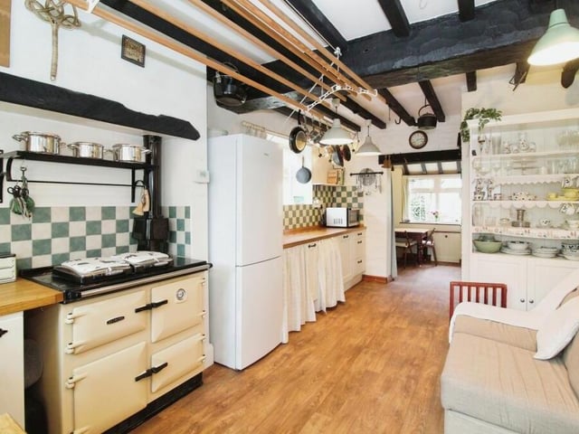 The busy and well-appointed retro kitchen and dining area combines functionality and style. The ceiling beams take the eye but the gas-fired Rayburn Aga cooker is a central focal point.