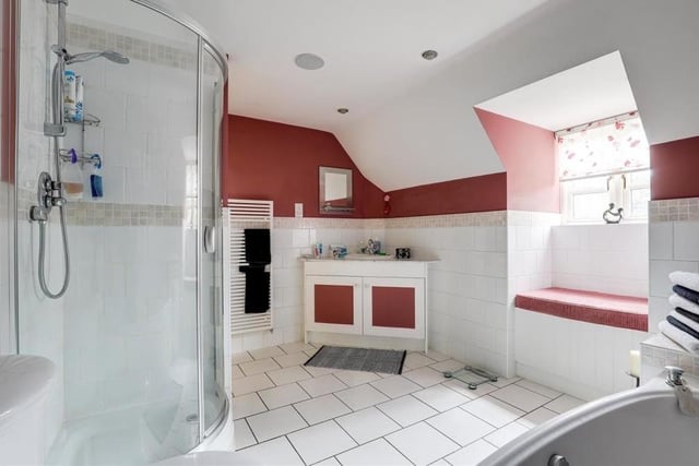 This is the bathroom on the second floor. It consists of a corner fitted shower enclosure with a mains-fed shower, low-flush WC, a vanity unit wash basin and a heated towel-rail. The floor is tiled.