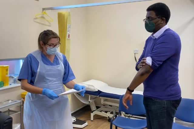 MP Darren Henry rolling up his sleeve for his Covid-19 vaccine earlier this year.