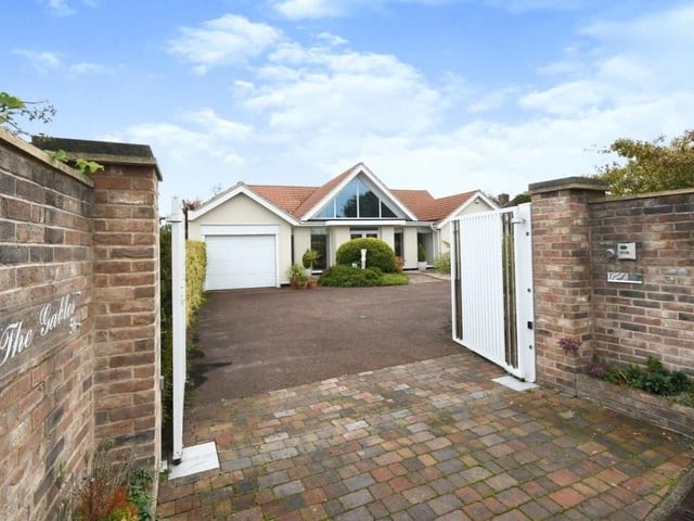 Returning to the front of the house, these electric gates open on to a tarmac driveway that leads to a garage, car port and standing area for a caravan.