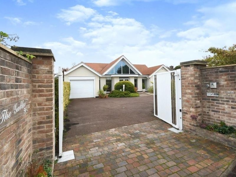 Returning to the front of the house, these electric gates open on to a tarmac driveway that leads to a garage, car port and standing area for a caravan.