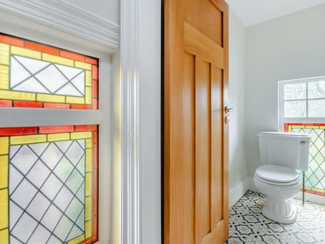 There are toilets on both the ground floor and first floor at the £625,000 house, This one upstairs features a stained glass window pane.