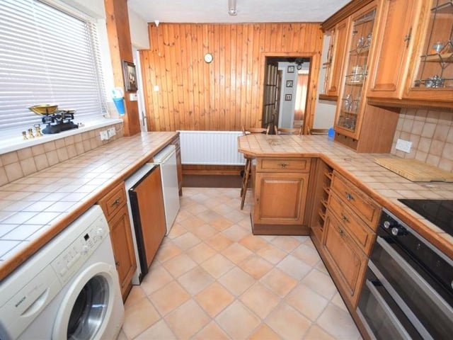 This is the breakfast kitchen from a different angle. It is fitted with a double oven and four-ring halogen hob. There is also an integrated dishwasher, plumbing for a washing machine and a practical side door leading straight on to the driveway.