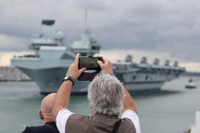 A person takes a photograph as HMS Queen Elizabeth leaves Portsmouth. Picture: Andrew Matthews/PA Wire
