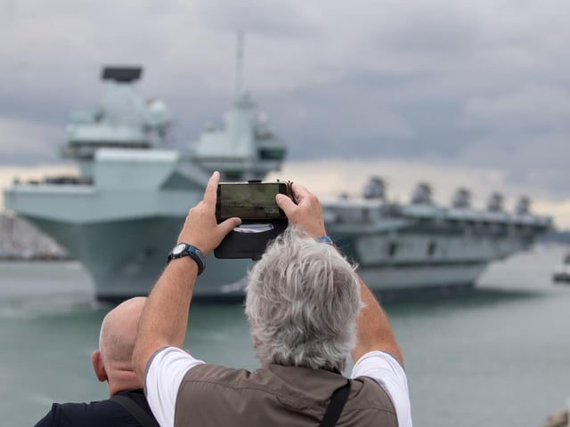 A person takes a photograph as HMS Queen Elizabeth leaves Portsmouth. Picture: Andrew Matthews/PA Wire