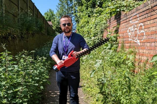Coun Ben Brown manned the hedgecutter to tackle the overgrown pathway himself