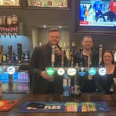 Coun Ben Bradley, left, pulls a pint at the Green Dragon with operator Daniel Bolton and deputy manager Danielle Stevenson.