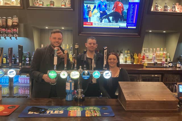 Coun Ben Bradley, left, pulls a pint at the Green Dragon with operator Daniel Bolton and deputy manager Danielle Stevenson.
