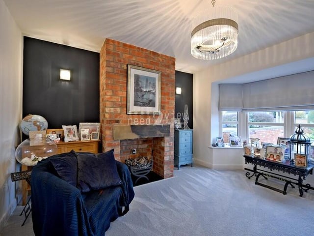 The second lounge is equally impressive and also benefits from a bay window at the front of the property. It also features an exposed-brick fireplace.