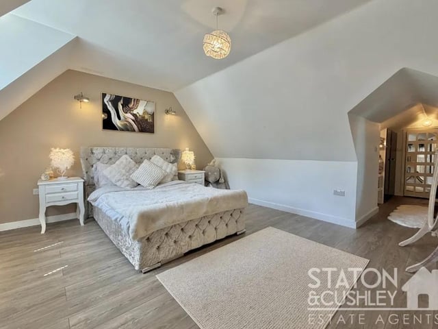 The impressive master suite offers fitted wardrobes and a sleek en-suite shower room finished with contemporary fittings and stylish marble-effect wall panels, creating a luxurious private sanctuary.