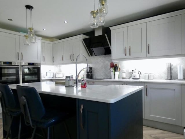 At the heart of the ground floor is this modern fitted kitchen, offering countertops, integrated appliances and an open-plan dining area.