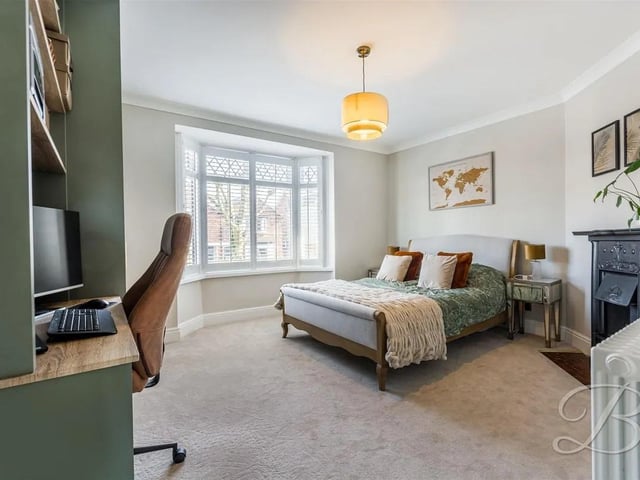 Stunning bedroom with carpeted flooring, central heating radiator, built in wardrobes and a bay window to the front elevation.