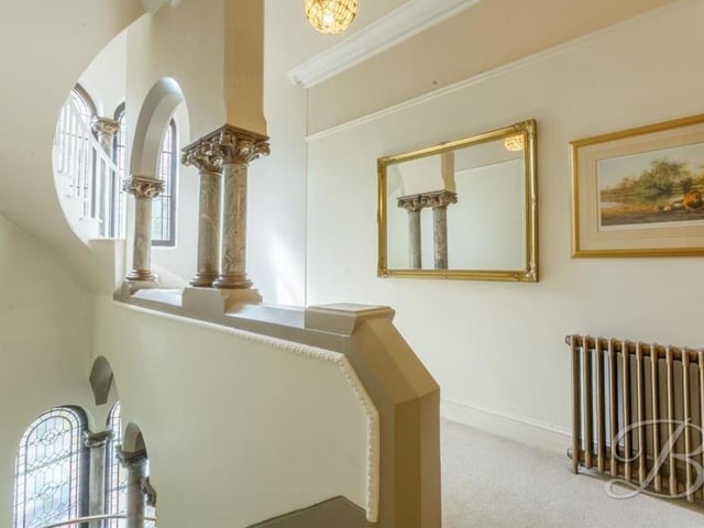 This image gives you a better view of the period marble columns and stained glass windows on the classy landing