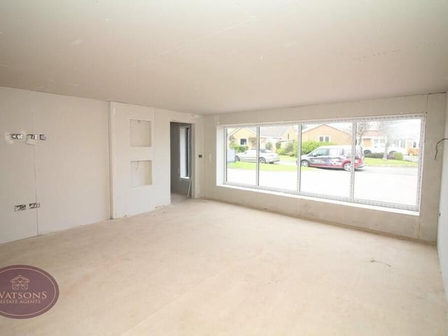 The spacious lounge features picture windows facing the front of the Olympus Court property.