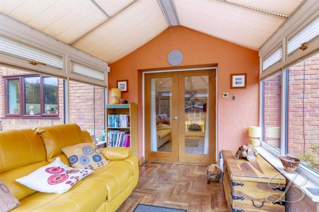 Through the French doors of the snug and into this comfortable conservatory. The room is distinguished by its parquet flooring, surrounding windows and door to the garden.