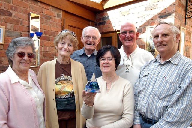 Mary Brown, third right, presents the first of the new gifts given by the Mansfield Sister Cities Association in 2007 to visitors from other Mansfields to Betty, second left, and John Franklin, third left, who were visiting the Town from Mansfield in Ontario. Akso pictured from the left are Betty Ball. Dennis Ball and Don Brown