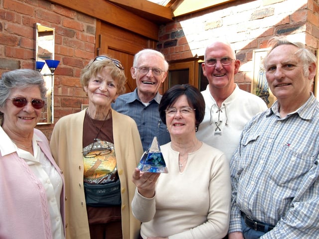 Mary Brown, third right, presents the first of the new gifts given by the Mansfield Sister Cities Association in 2007 to visitors from other Mansfields to Betty, second left, and John Franklin, third left, who were visiting the Town from Mansfield in Ontario. Akso pictured from the left are Betty Ball. Dennis Ball and Don Brown