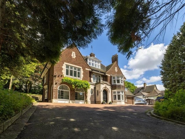 The sweeping driveway that leads to the imposing facade of the property.