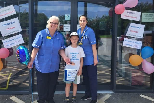Thomas finished his walk at the John Eastwood Hospice in Sutton. He is pictured holding his collections bucket with hospice staff. Photo: submitted.