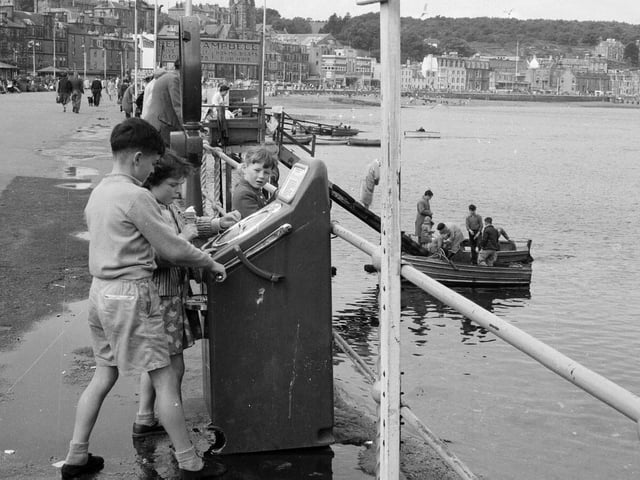 Children playing on an amusement machine on the waterfront at Rothesay, Bute