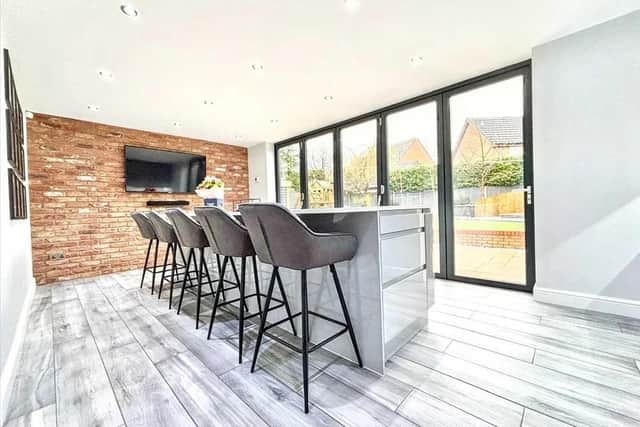 The kitchen benefits from triple glazed bi-folding doors leading out to the enclosed garden, bathing the area in natural light.