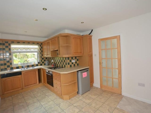 Picture number three focuses on the breakfast kitchen, which has a Bosch oven, Bosch four-ring electric hob with extractor over, and integrated dishwasher.