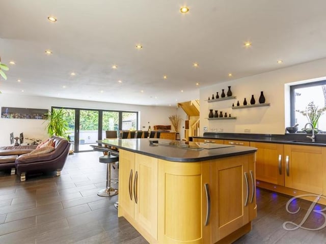 A second shot off the cracking kitchen. It features an induction hob with integrated extractor fan above, and an inset sink and drainer with chrome mixer tap above.
