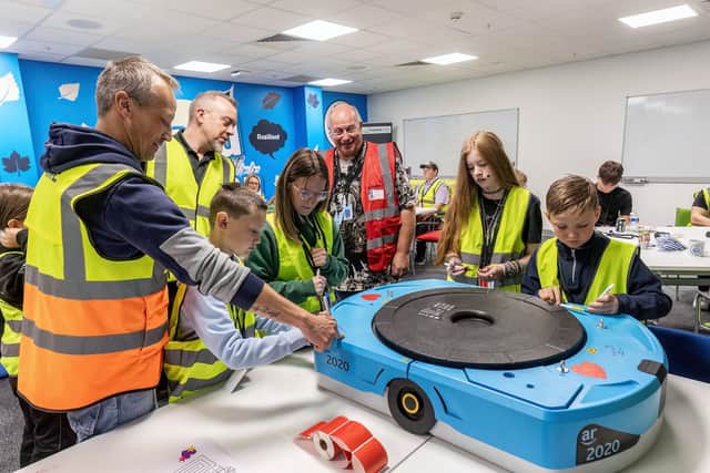 Amazon employees and their children enjoying the Amazon Robotics demonstration