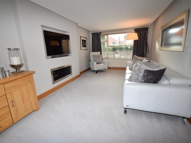 The ground floor is completed by this smart sitting room, which is a perfect space for relaxation. It features an inset living-flame gas fire, window overlooking the front of the property and more bi-folding doors at the back.
