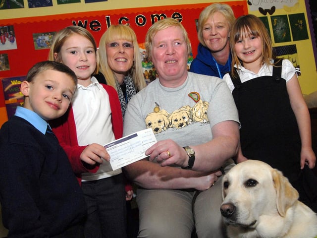 Staff and youngsters from the Ashfield Playcare Scheme present Mrs Kathleen Patten and her dog Vogue with a £256.65 cheque for the Guide Dogs for the Blind Association following  a fund raising green day and Halloween event. 2010.