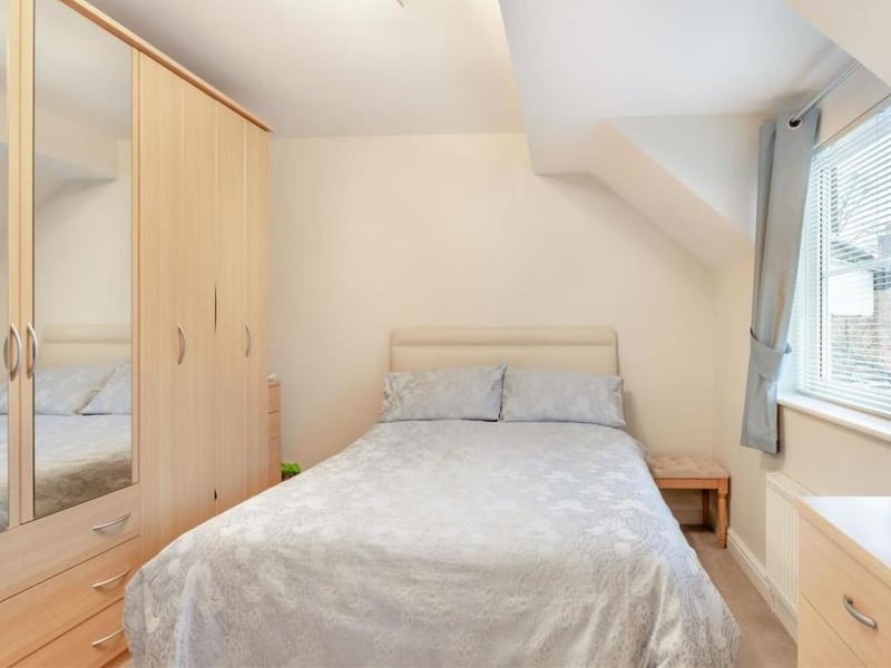 The second bedroom has plenty of space for storage, including sizeable wardrobes. It overlooks the front of the New Mill Lane property.