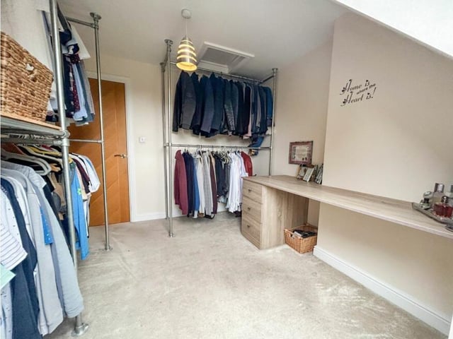 One of the bedrooms benefits from this good-sized, fitting dressing room.