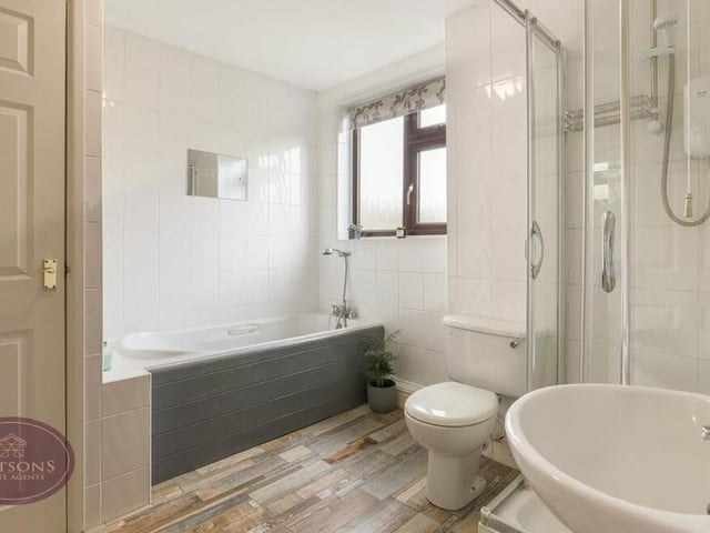 This stylish family bathroom can be found in the first floor of the £475,000 Bagthorpe property. A four-piece white suite comprises a bath, shower cubicle with electric shower, pedestal sink unit and WC -- plus an airing cupboard and radiator.