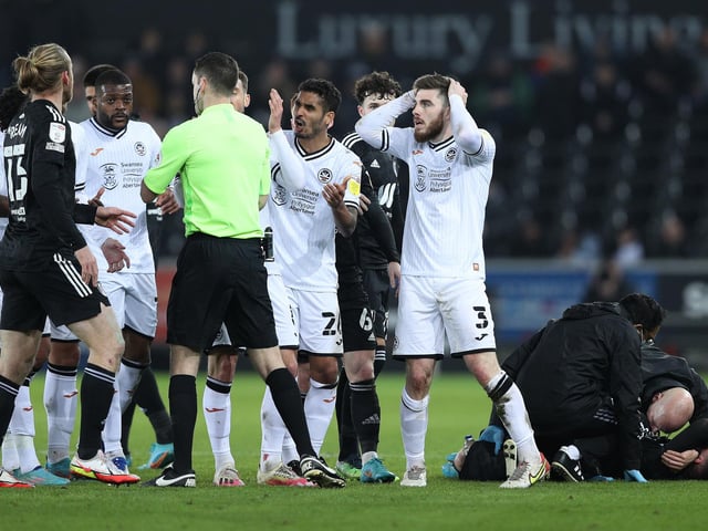 Swansea City players join Ryan Manning as he protests to referee Jarred Gillett after receiving a red card after his foul on Harry Wilson of Fulham.