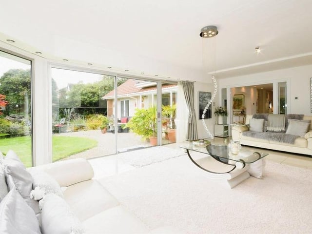 This image encapsulates perfectly the magnificent floor-to-ceiling windows that overlook the beautiful garden.