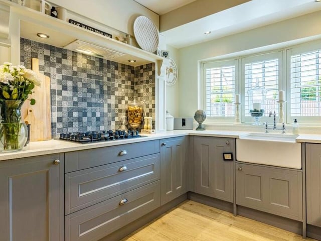 The dining kitchen has a touch of class about it, with a range of matching wall and base units and granite work surfaces incorporating an inset Belfast sink. A double-glazed bay window, with integrated shutter-blinds, overlooks the front of the property.
