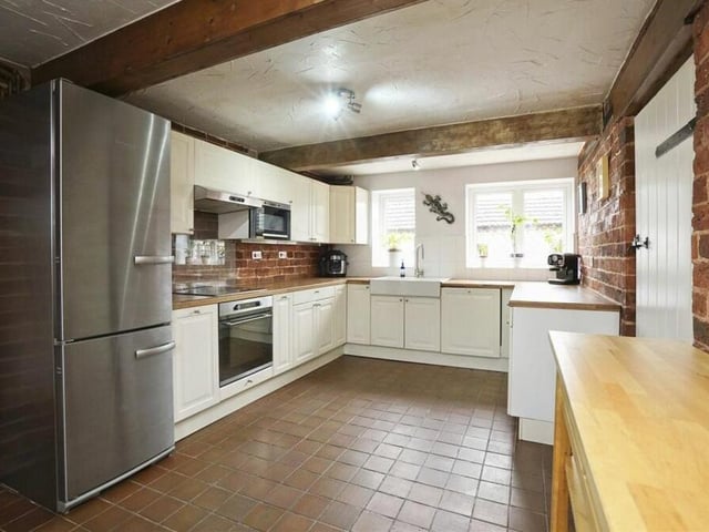 The kitchen features a range of modern, fitted wall and base units, as well as a ceramic double sink.