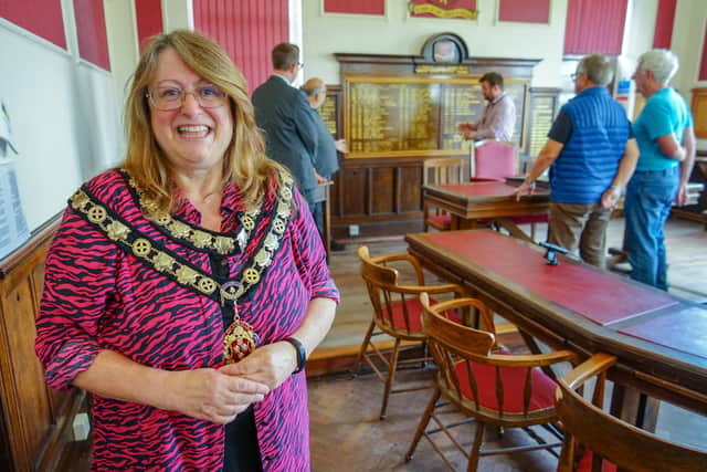 Coun Karen Hardy, chairwoman of Warsop Council, in the council chamber with a tour in the background. Photo: Brian Eyre