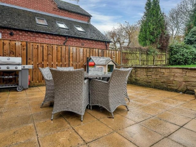 One of the back garden's prized highlights is this sunken-style patio area with stone walling and space for seating and barbecues.