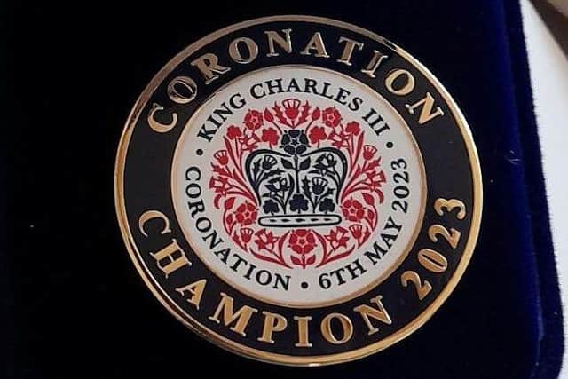 The coronation champion pin badge.