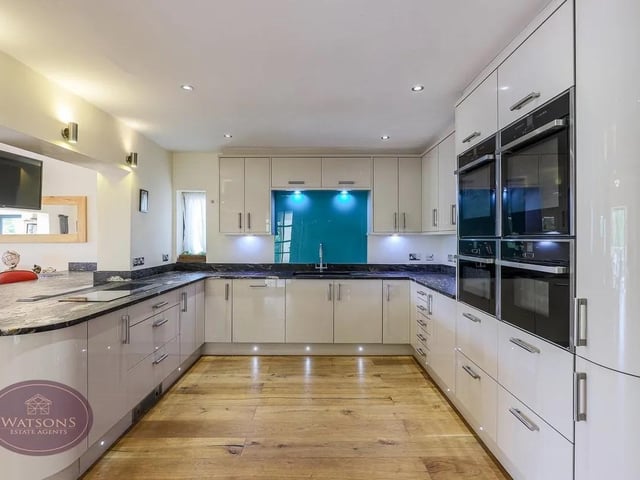 Integrated appliances including fridge freezer, dishwasher, eye level double electric ovens, integrated microwave and steamer, induction hob, wine cooler and breakfast bar.